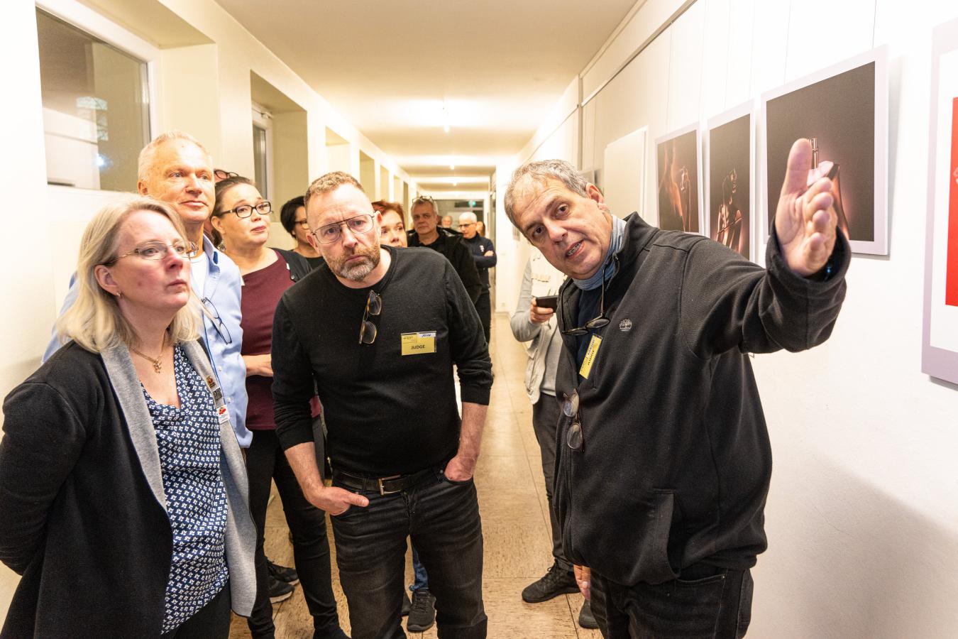 Gäste aus dem In- und Ausland überzeugten sich in der Ausstellung mit dem Erklärungen von Bernd Gassner, stellv. Bundesinnungsmeister (rechts) von der hohen Qualität der Fotos (Foto: Henning Arndt)